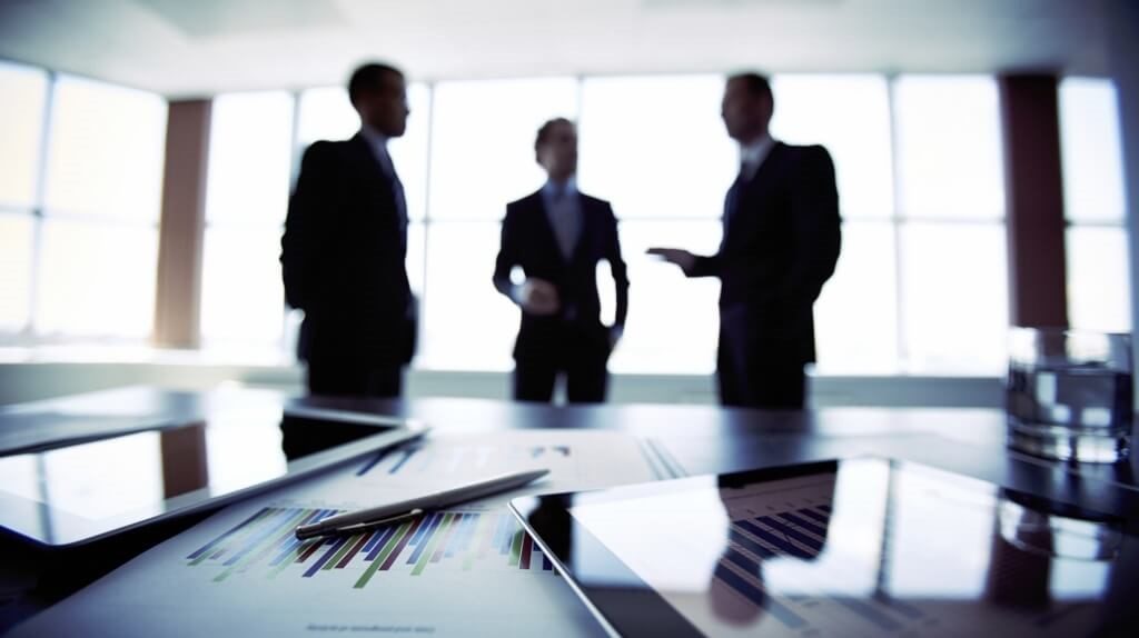 Two negotiators reaching agreement across a table