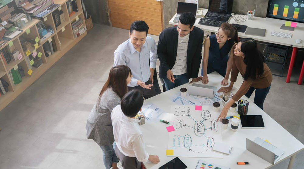 A team brainstorming around a table, seen from above