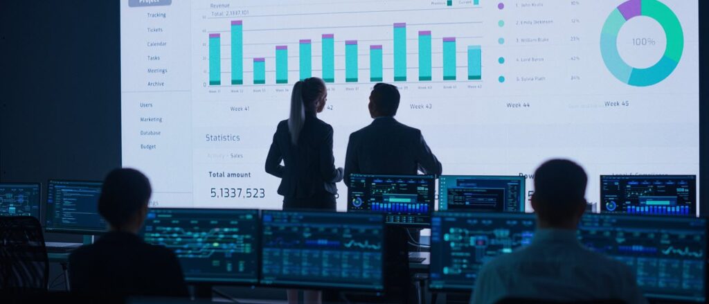 Analysts reviewing dashboards on a display wall